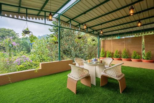 um pátio com uma mesa e cadeiras na relva em Sanjwat Homestays Bhimtal - Largest 5BR Luxury Orchard Villa em Bhimtal