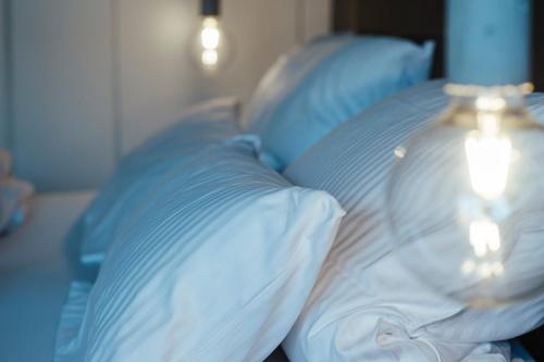 a bed with blue and white pillows and a lamp at Hotel Lindenhof in Erkelenz