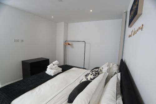 a bedroom with a bed with a mirror and towels at Luxury Apartments in Central Watford in Watford