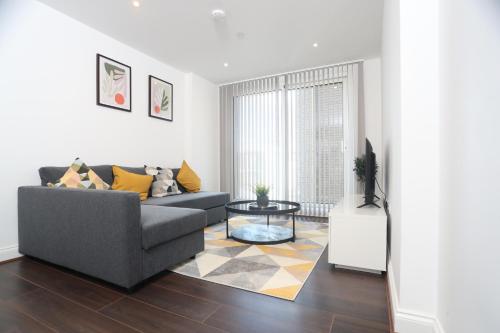 a living room with a couch and a table at Luxury Apartments in Central Watford in Watford