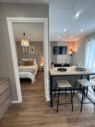 1 dormitorio con 1 cama, mesa y sillas en Le 28 Bis - Moderne & Confort, en La Roche-sur-Yon