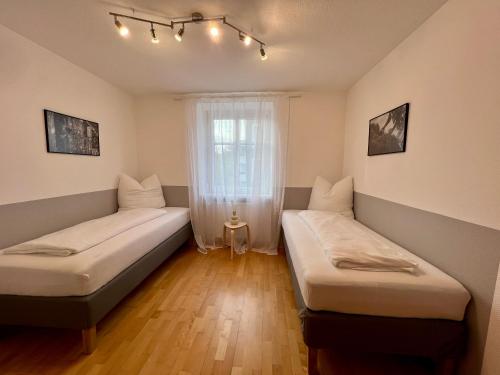 two beds in a room with a window at Stadthaus 1911 in Bludenz