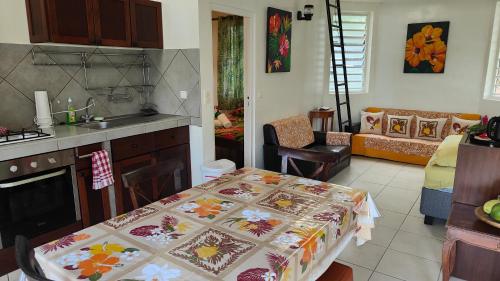 een keuken met een tafel en een woonkamer bij TIVA PERL LODGE TAHAA in Tiva