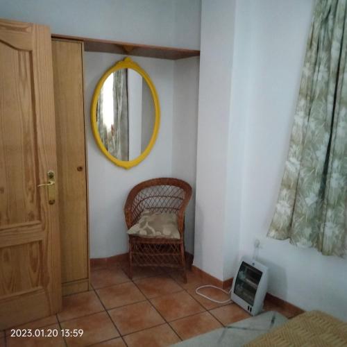 a room with a wicker chair and a mirror at Apartamento vacacional en la Alpujarra in Laroles