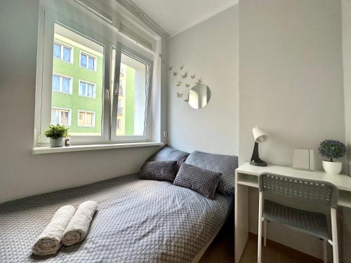 a small bedroom with a bed and a window at MMRent Spring Room in Gdańsk