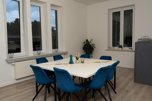 a dining room with a white table and blue chairs at Downtown Apartments in Bremen