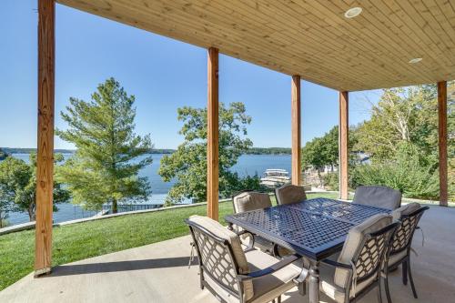 a table and chairs on a patio with a view of the water at Spacious Lake of the Ozarks Escape with Deck and Views in Linn Creek