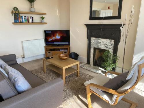 a living room with a couch and a fireplace at Stunning town centre apartment with sea views in Worthing