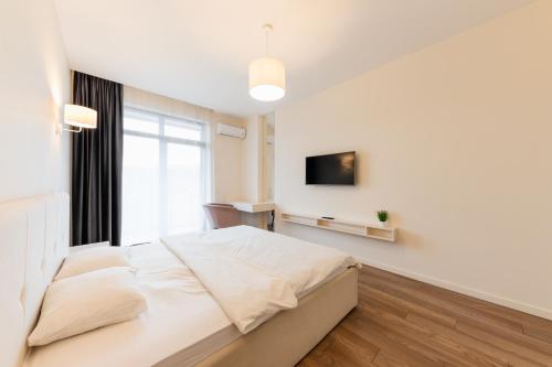 biała sypialnia z dużym łóżkiem i oknem w obiekcie Luxury Apartments “Dream City” w mieście Użhorod