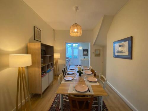 uma longa sala de jantar com uma longa mesa com cadeiras em Maison de Charme - 4 Chambres - Courette & Parking Gratuit em Amiens