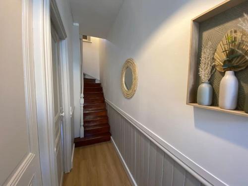 a hallway with a staircase with a mirror and vases at Maison de Charme - 4 Chambres - Courette & Parking Gratuit in Amiens
