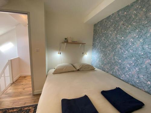 a bedroom with a large bed with two pillows on it at Maison de Charme - 4 Chambres - Courette & Parking Gratuit in Amiens