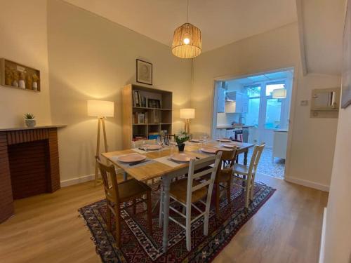 a dining room with a long table and chairs at Maison de Charme - 4 Chambres - Courette & Parking Gratuit in Amiens