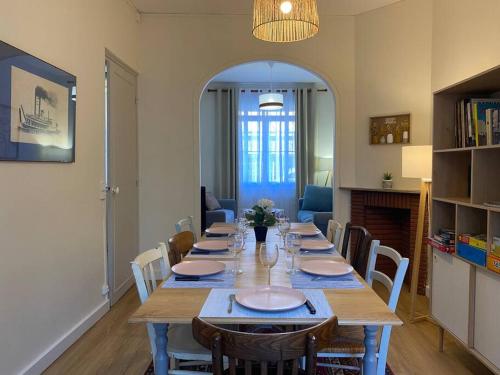 a dining room with a long table with chairs at Maison de Charme - 4 Chambres - Courette & Parking Gratuit in Amiens