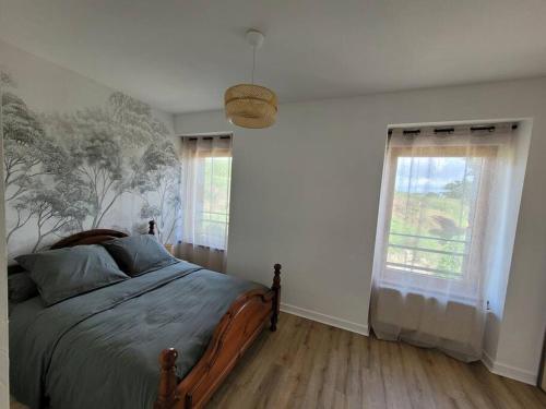 um quarto com uma cama e duas janelas em Logement 2 à 4 pers - moulin em Saint-Carreuc