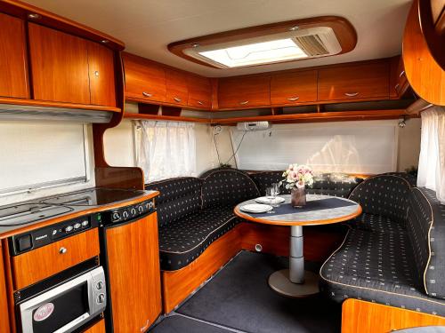 a small kitchen with a table and chairs in an rv at Campervan romantic getaway in Old Town Brasov in Braşov