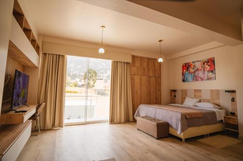 a bedroom with a bed and a large window at Suite Spa Puñuykuna in Cajamarca