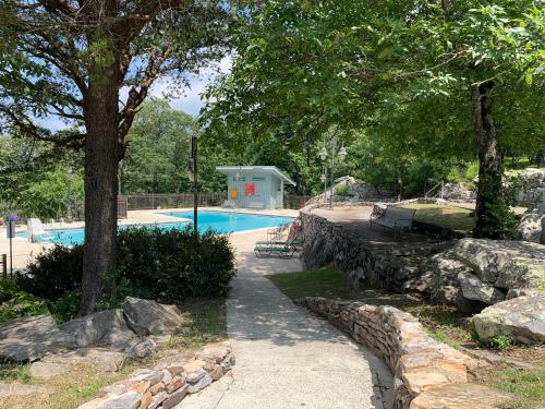 una piscina con una pared de piedra junto a un árbol en Luxury Spacious Glamping with Lake View, en Delta