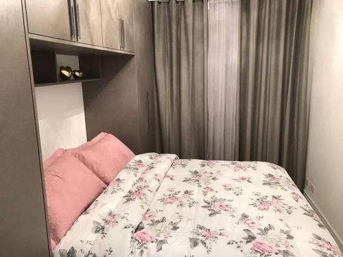 1 dormitorio con 1 cama con edredón de flores en Beverly Hills House, en Curitiba