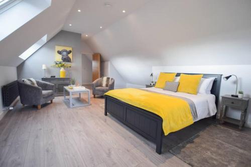 een slaapkamer met een bed met een gele deken bij Nr Bicester Village 5 Star Luxury on farm in Piddington