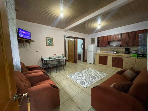 uma sala de estar com sofás e uma cozinha com uma mesa em Complejo Ecoturistico Tamandua em Drake