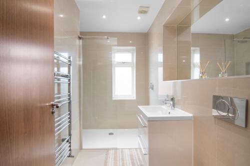 a bathroom with a sink and a shower at Luxury Apartment in Town Centre with Free Gated Parking in Potters Bar
