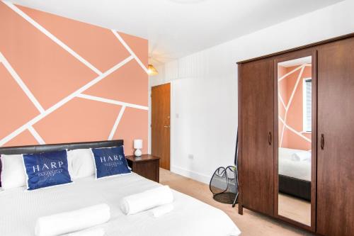 a bedroom with a bed and a wooden cabinet at Luxury Apartment in Town Centre with Free Gated Parking in Potters Bar
