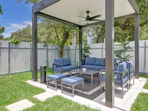 a gazebo with blue chairs and a table at Chic Miami Escape- 4 Bedrooms, Game Room, Fire Pit, Pergola in North Miami Beach