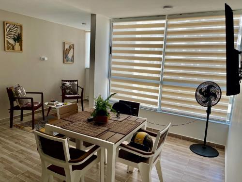 sala de estar con mesa, sillas y ventilador en Hermoso apartamento para estrenar, en Barranquilla