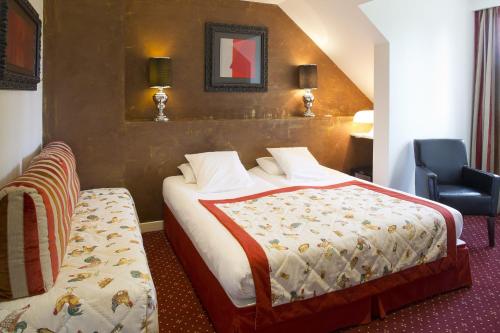 En eller flere senge i et værelse på Le Dracy Hôtel et Spa