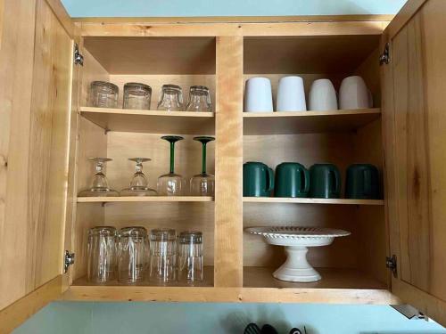 a cupboard filled with lots of glasses and vases at Whiskey Run Cabin, Spectacular Mountain Views in Bryson City