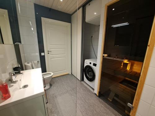 La salle de bains est pourvue de toilettes, d'un lavabo et d'une douche. dans l'établissement ALEX - bright, stylish apartment with sauna, built in 2023, à Närpiö