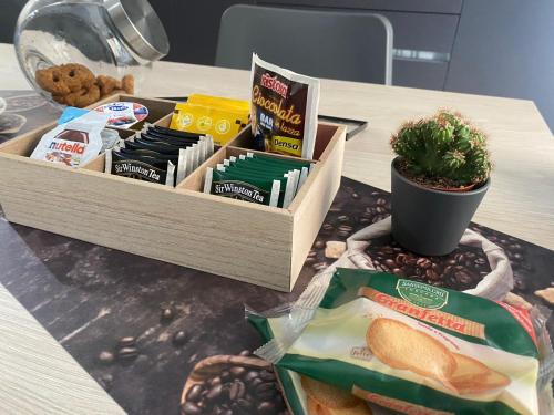 una mesa con una caja de comida y una planta en B&B IL PALCOSCENICO, en Salerno