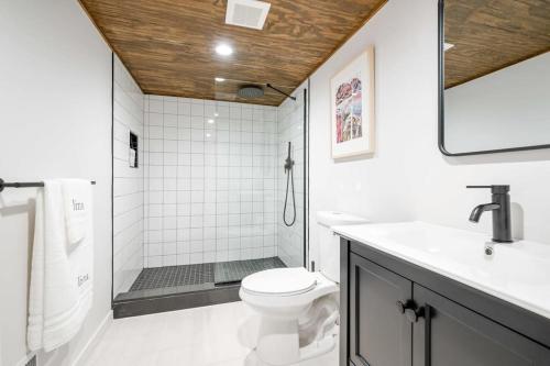 a white bathroom with a toilet and a shower at Chateau Bungalow - Ski Belleayre, Hunter in Shandaken