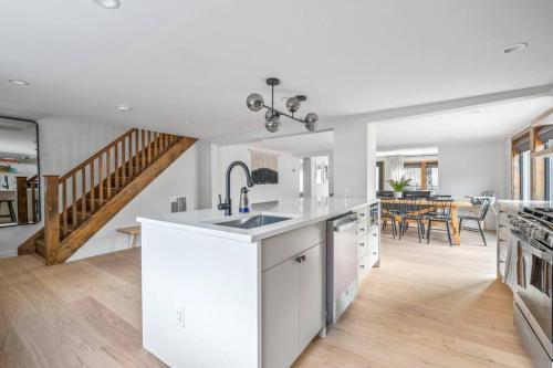 a kitchen with white cabinets and a dining room at Chateau Bungalow - Ski Belleayre, Hunter in Shandaken