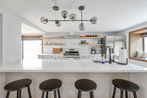 a kitchen with two bar stools and a white counter top at Chateau Bungalow - Ski Belleayre, Hunter in Shandaken
