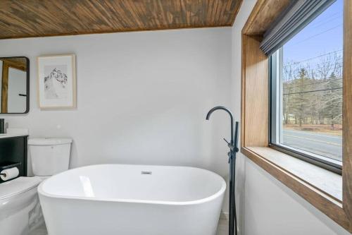a white bath tub in a bathroom with a window at Chateau Bungalow - Ski Belleayre, Hunter in Shandaken