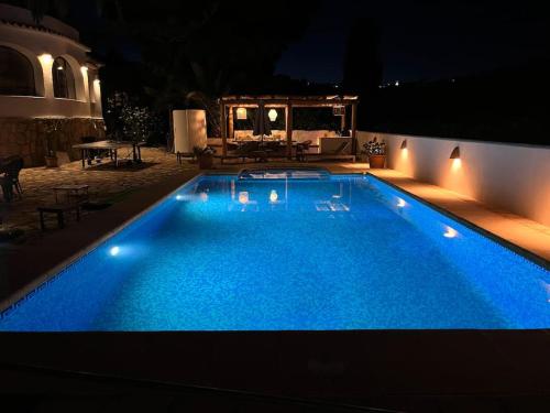 duży niebieski basen w nocy z oświetleniem w obiekcie Casa Jules Cesar w mieście Benissa