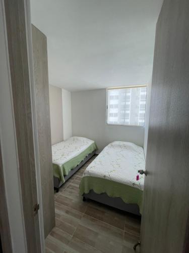 2 camas en una habitación pequeña con ventana en Hermoso apartamento para estrenar, en Barranquilla