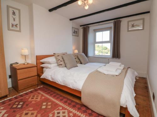 um quarto com uma cama grande e uma janela em Potters Cottage em Lynton