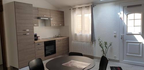 uma pequena cozinha com uma mesa e uma mesa e cadeiras em Studio calme em Mitry-Mory