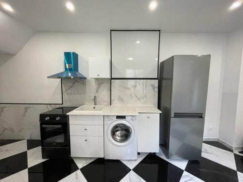 eine Küche mit einer Waschmaschine und einem Kühlschrank in der Unterkunft Entire residence Stade de France in Aubervilliers