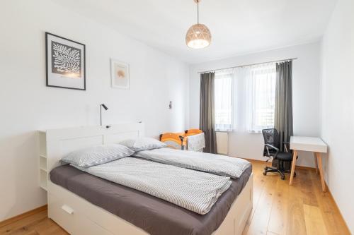 a bedroom with a bed and a desk in it at Przytulny apartament z parkingiem in Łódź