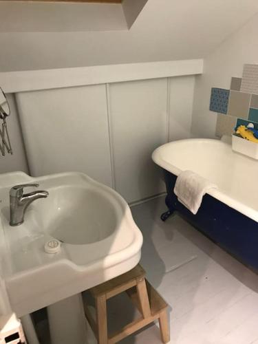 une salle de bain avec un lavabo et une baignoire dans l'établissement Maison proche stade de France et village olympique, à Enghien-les-Bains