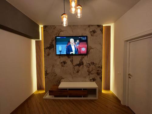 uma sala de estar com uma televisão na parede em Neversea Suite em Constança