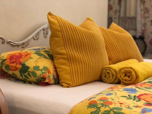 a bed with yellow pillows and a yellow blanket at Sharm Sweet Studio City Center Kamppi in Helsinki