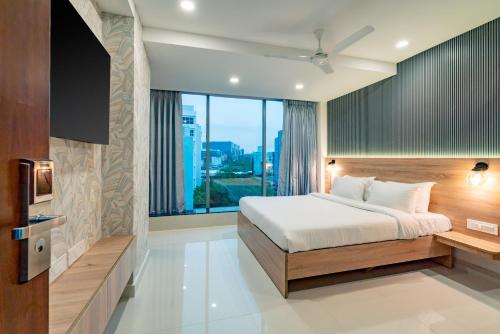 a bedroom with a bed and a large window at Harvey's Hotels (Gachibowli) in Hyderabad