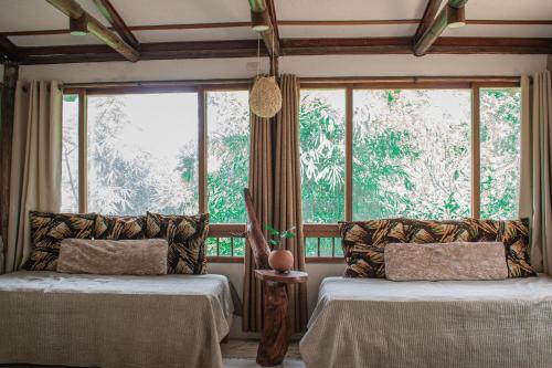 a room with two beds and a large window at EKOPARQUE LUNAFOREST in Arroyo de Piedra