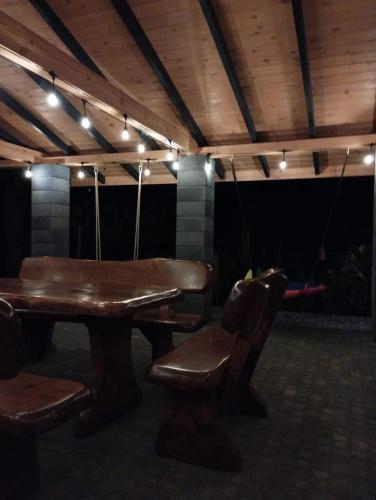 a wooden table and chairs in a room with lights at Świerkówka in Siemianówka