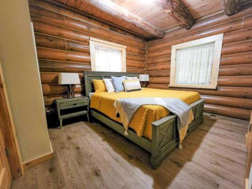 a bedroom with a bed in a log cabin at Wilderness Vista Retreat in Reed City